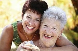 adult daughter hugging her senior mother