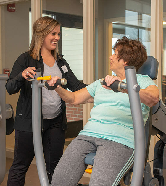 senior woman exercising with an employee