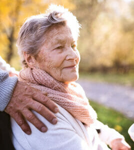 senior woman in wheelchair with hand on her shoulder