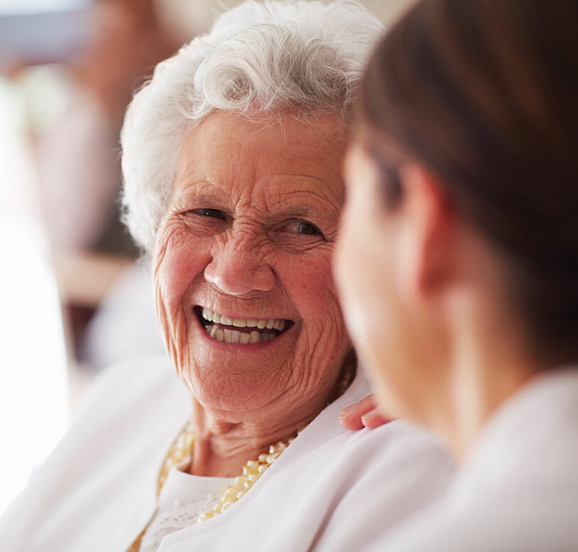 senior woman laughing with staff
