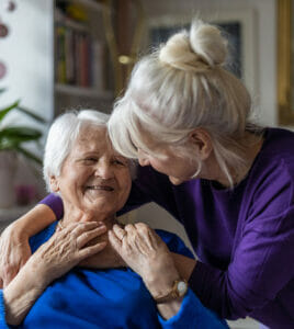 senior woman getting a hug from her daughter